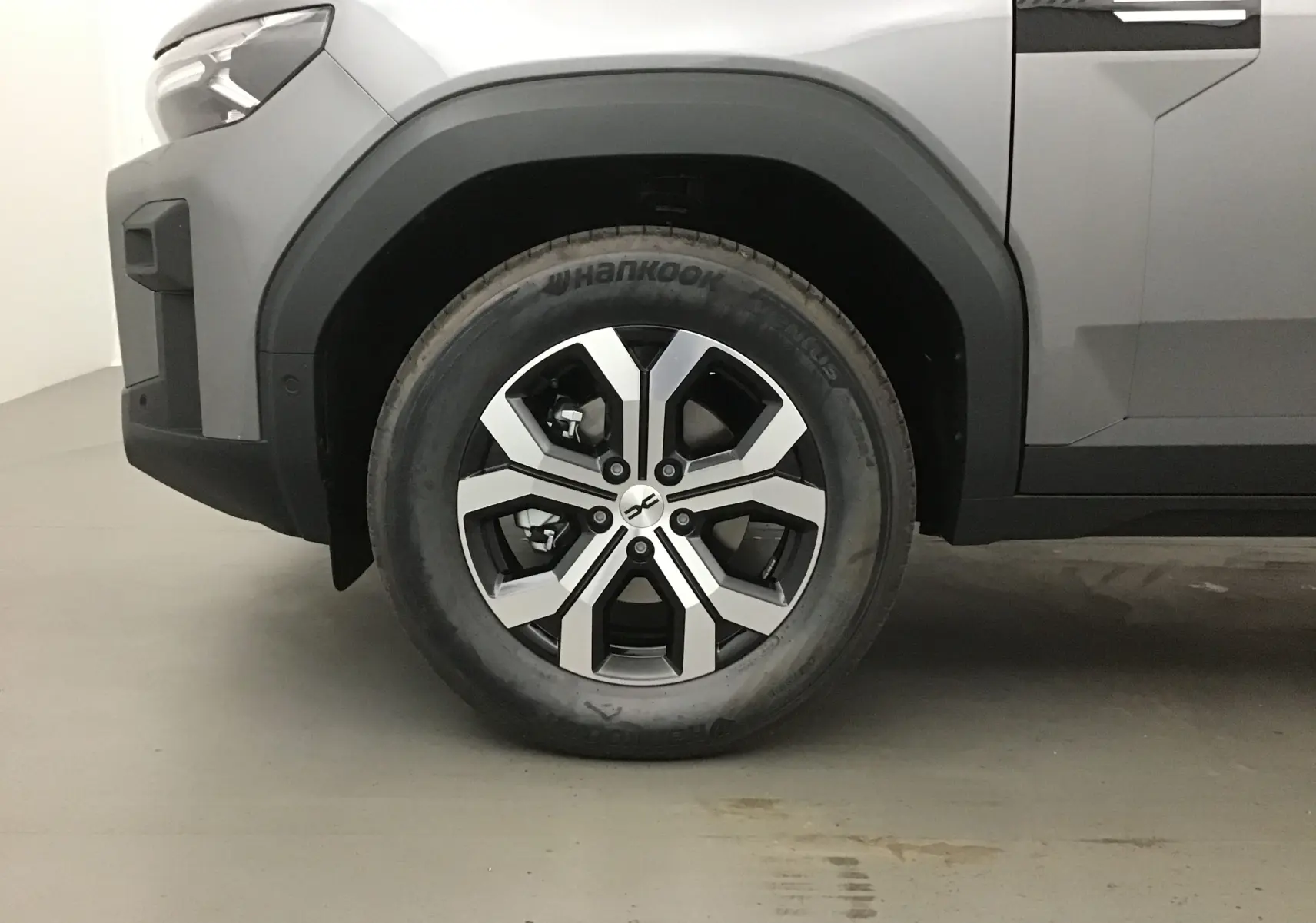 Gros plan sur la roue avant gauche du Dacia Bigster gris schiste, mettant en valeur la jante alu au design moderne.