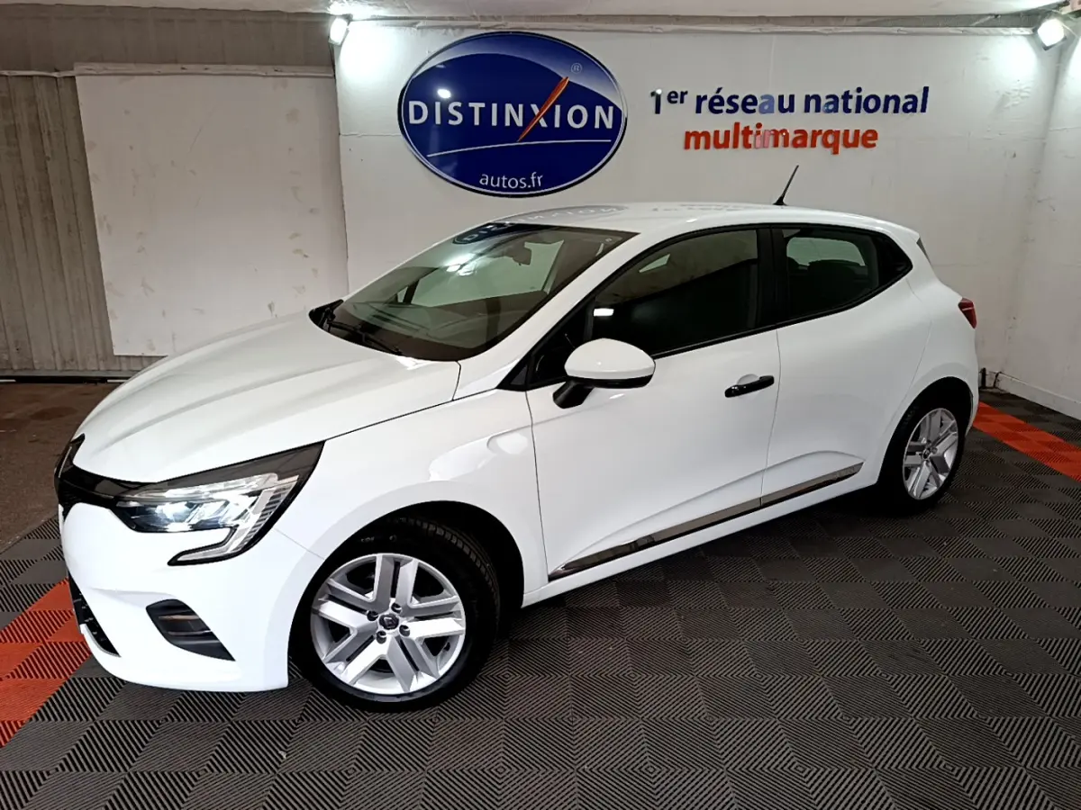 Renault Clio Business blanche vue de profil côté droit dans un showroom avec sol noir et rouge.
