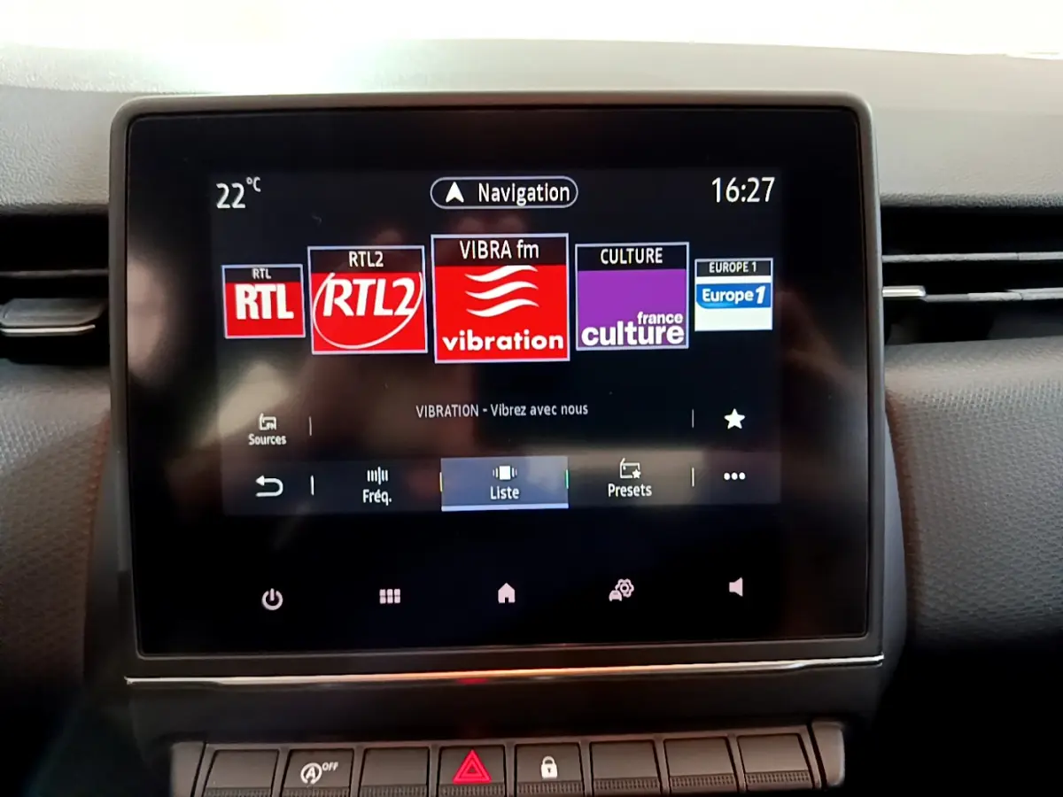 Écran tactile central de la Renault Clio Business 2021 affichant les stations radio et la navigation, vue frontale rapprochée.