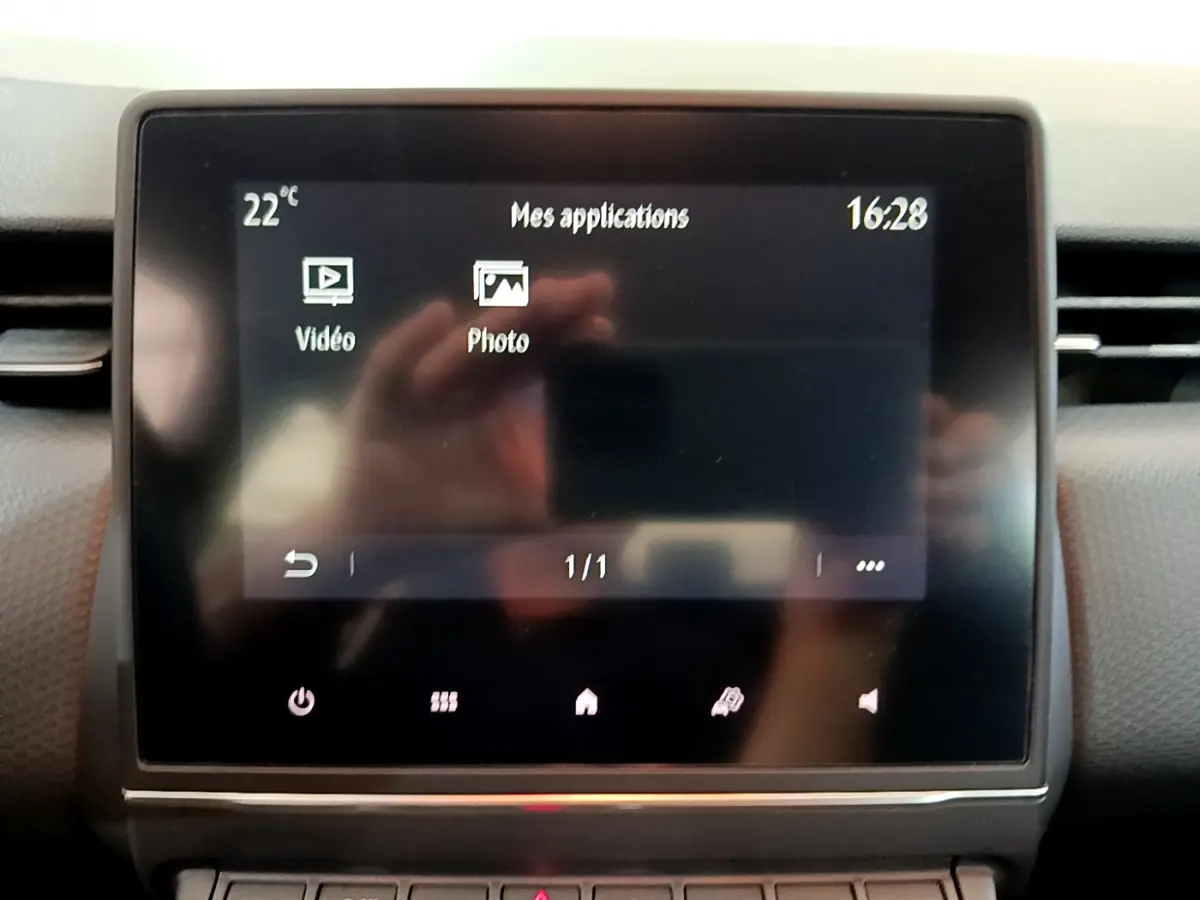 Écran tactile central de la Renault Clio Business blanche 2021 affichant les applications vidéo et photo.