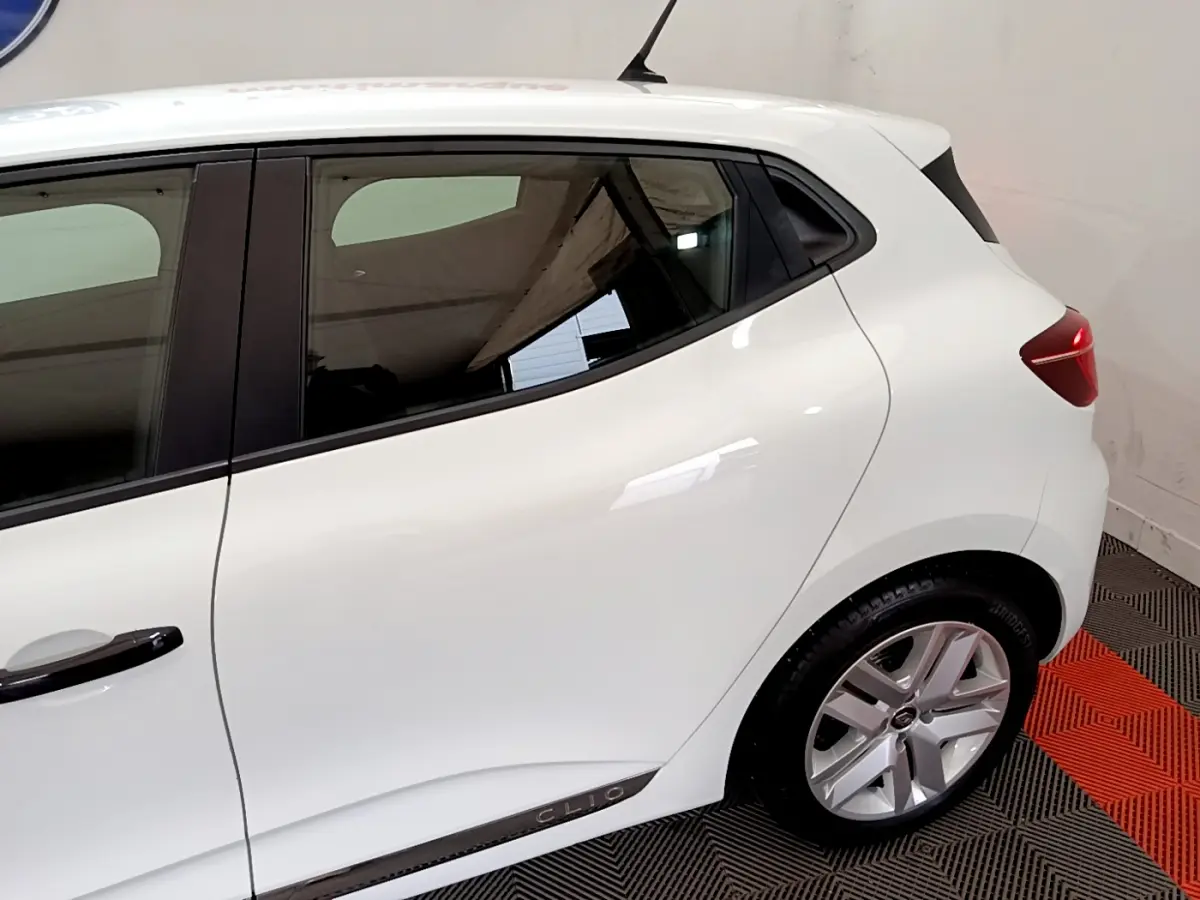 Vue latérale droite d'une Renault Clio Business blanche, mettant en valeur la ligne de caisse et la jante alliage.