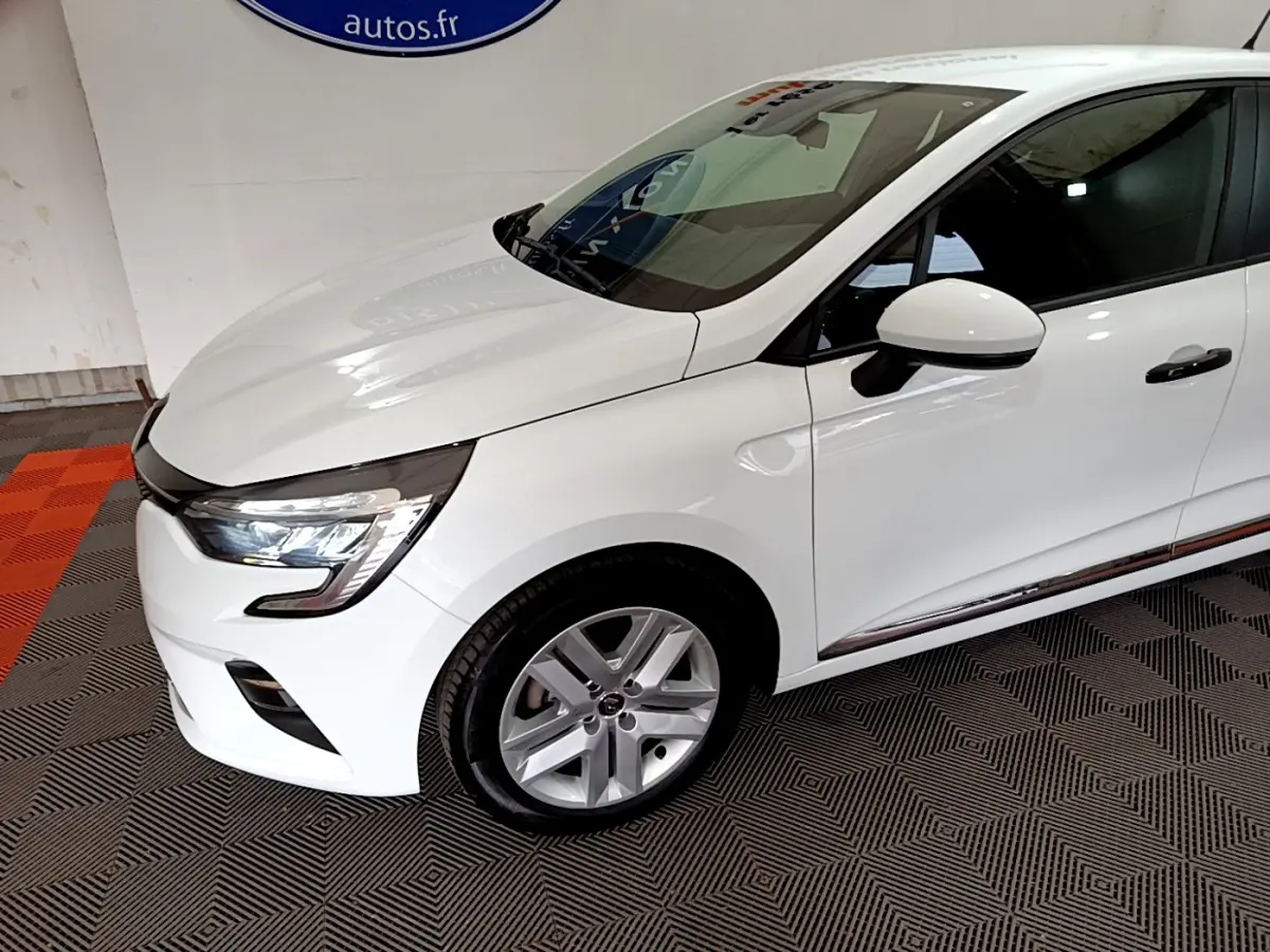 Renault Clio Business blanche vue de 3/4 avant droit, avec phares LED et jantes alliage argentées visibles.