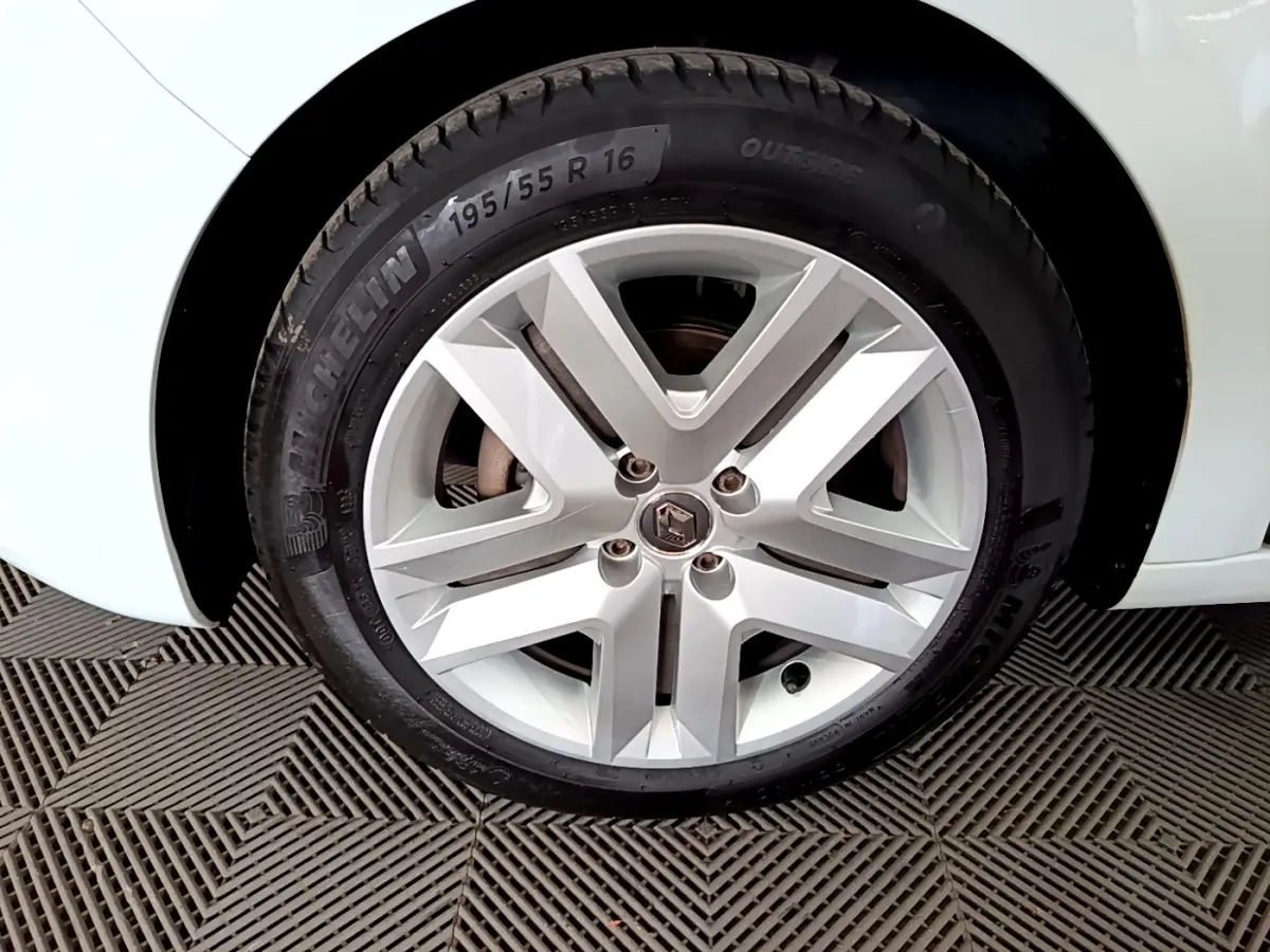 Gros plan sur la roue avant droite blanche d'une Renault Clio Business 2021 avec jante alliage et logo Renault central.