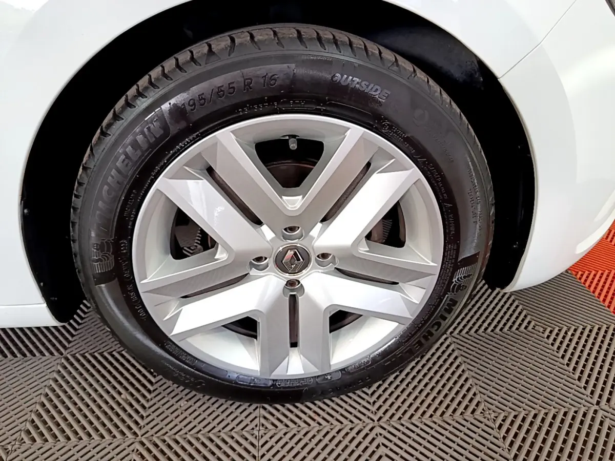 Gros plan sur la roue avant droite blanche d'une Renault Clio Business 2021 avec jante alliage et logo Renault au centre