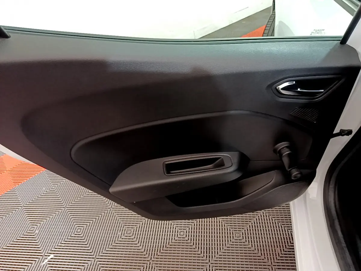 Vue intérieure de la porte avant droite noire d'une Renault Clio Business blanche avec poignée manuelle de vitre.