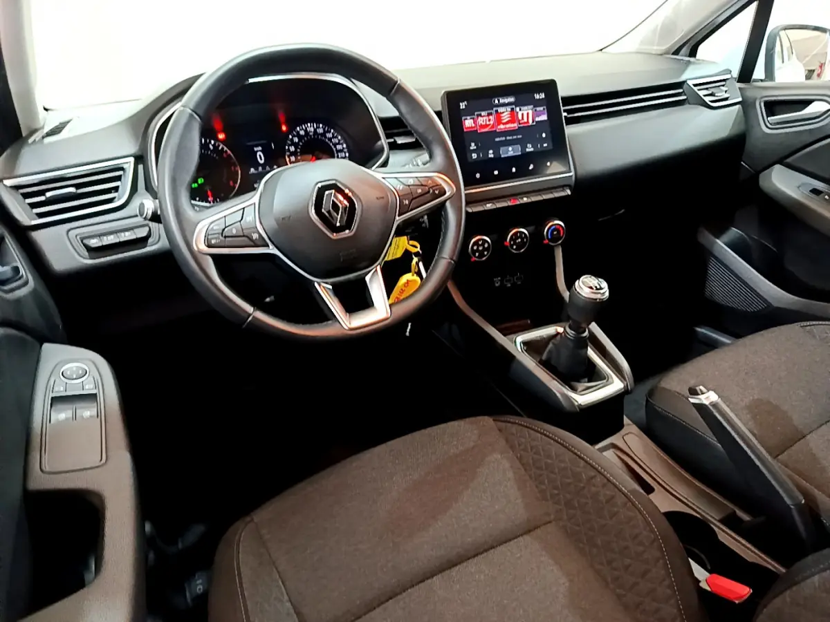 Intérieur de Renault Clio Business 2021 vu côté conducteur, volant cuir, écran tactile central et boîte manuelle noire.