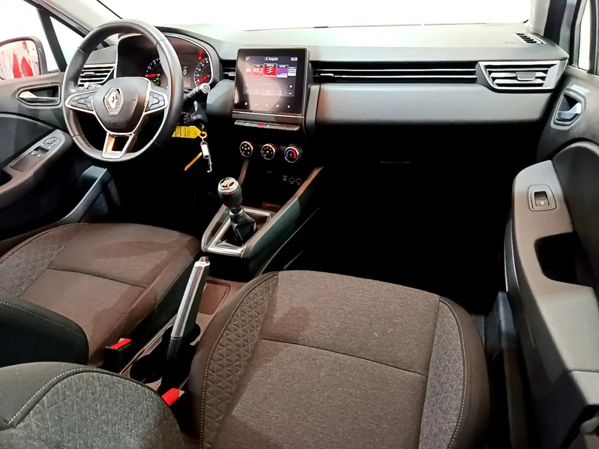 Intérieur avant de la Renault Clio Business 2021, vue côté conducteur, volant cuir et écran tactile central allumé.