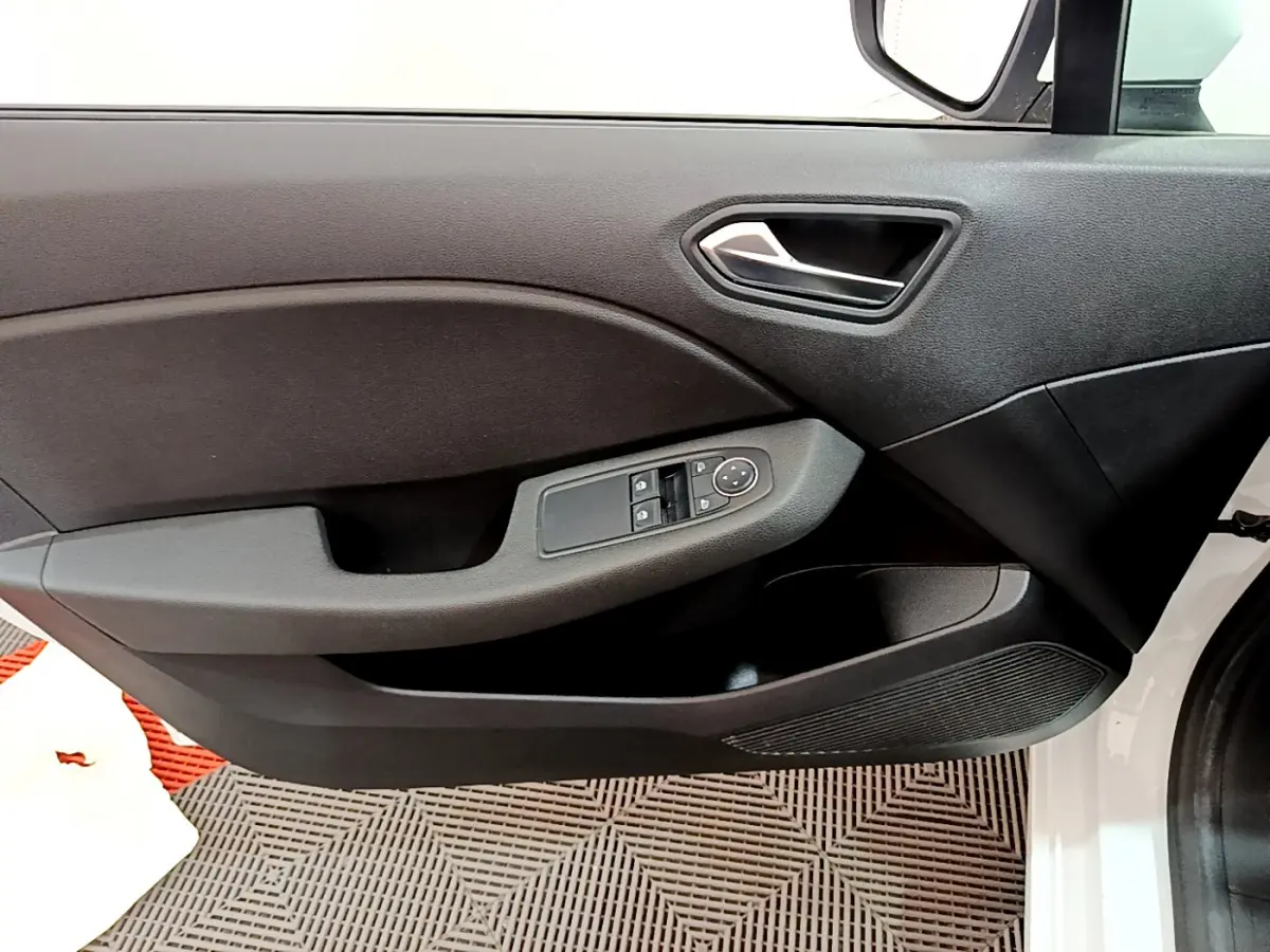 Vue rapprochée de la porte avant gauche blanche de la Renault Clio Business avec commandes électriques et poignée argentée.