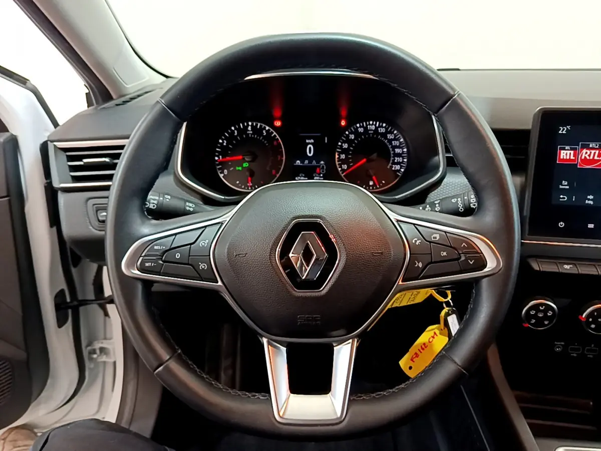 Vue centrée sur le volant cuir noir de la Renault Clio Business blanche 2021 avec tableau de bord et écran tactile visibles.