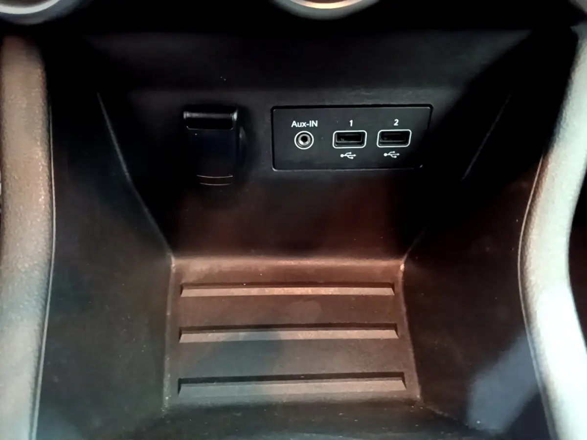 Vue rapprochée de la console centrale noire de la Renault Clio Business avec ports USB et prise Aux-IN visibles.