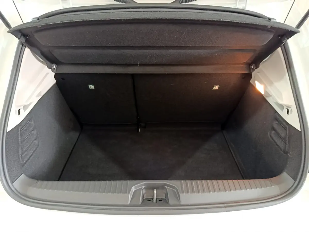 Coffre ouvert de la Renault Clio Business blanche 2021, vue arrière montrant l'espace de chargement vide et éclairé.