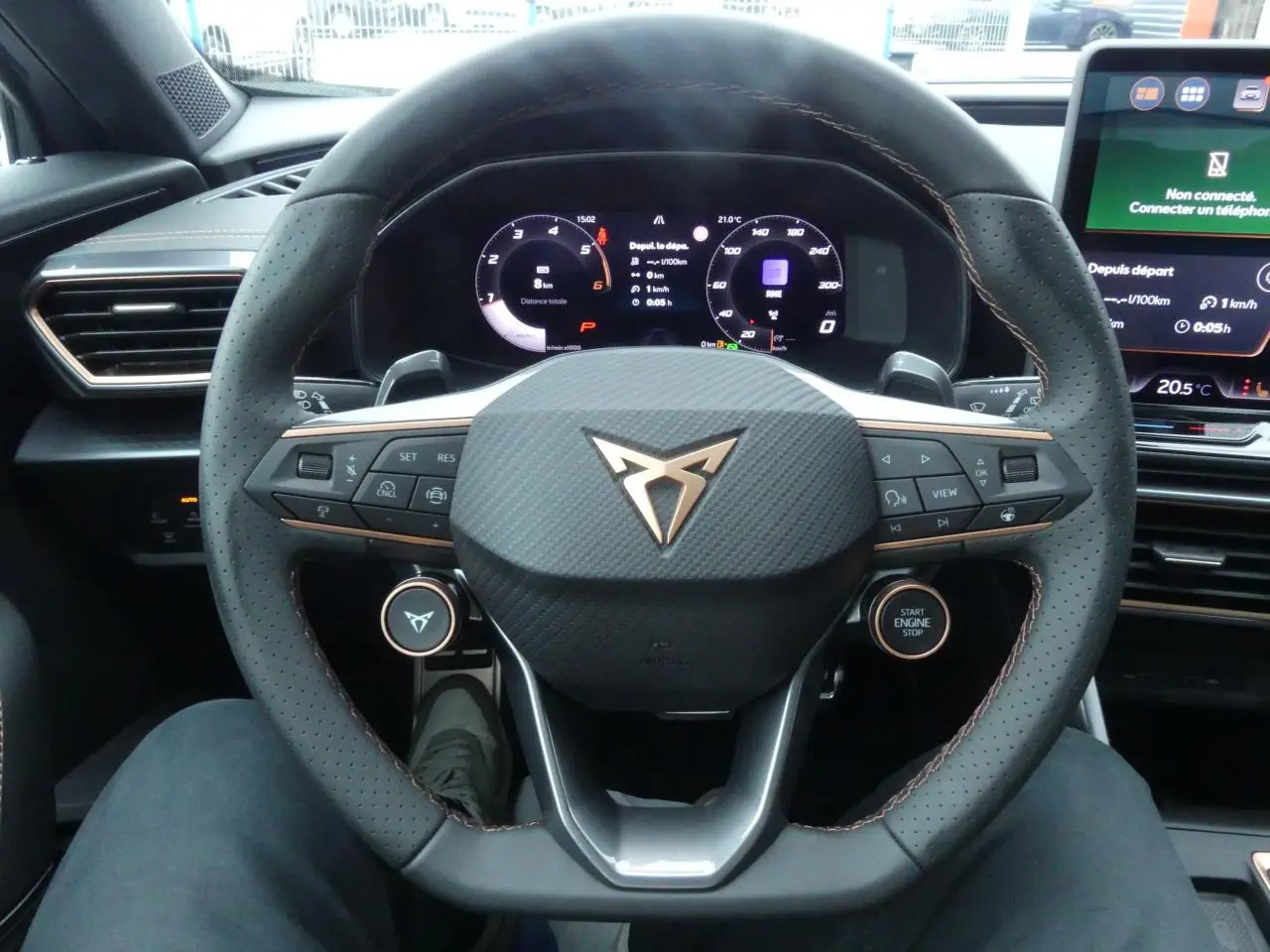 Vue rapprochée du volant perforé noir avec logo CUPRA cuivré et tableau de bord digital du Formentor Gris Graphène 2025.