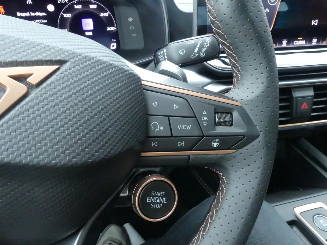 Gros plan sur le volant perforé noir avec surpiqûres cuivrées et bouton start/stop du CUPRA Formentor gris Graphène 2025.