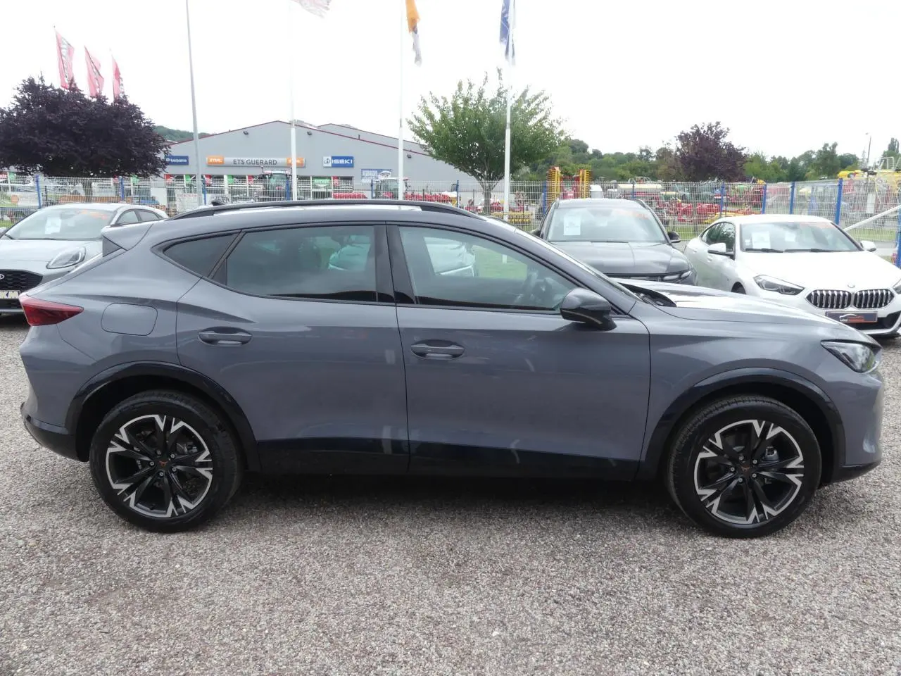 Profil côté gauche du CUPRA Formentor gris Graphène 2025 avec jantes alliage noires et coques de rétroviseurs noires.