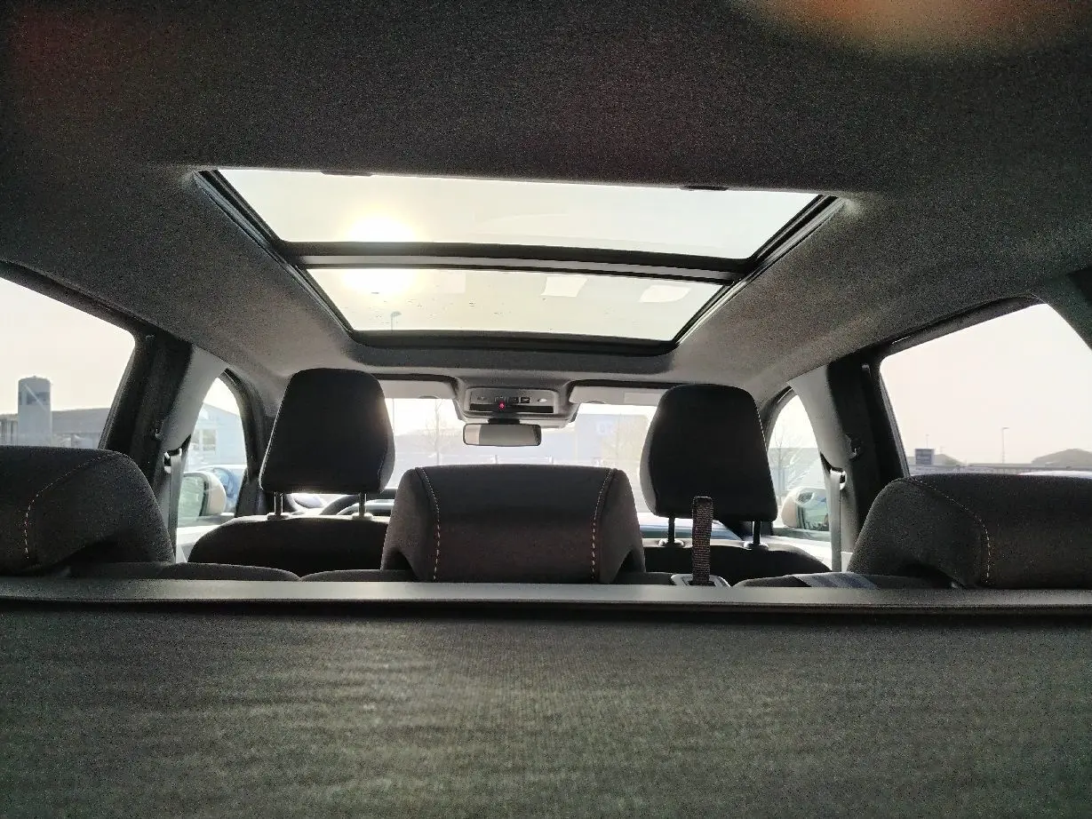 Intérieur du Dacia Bigster noir 2025 vu depuis le coffre, montrant les appuie-têtes et le toit panoramique.