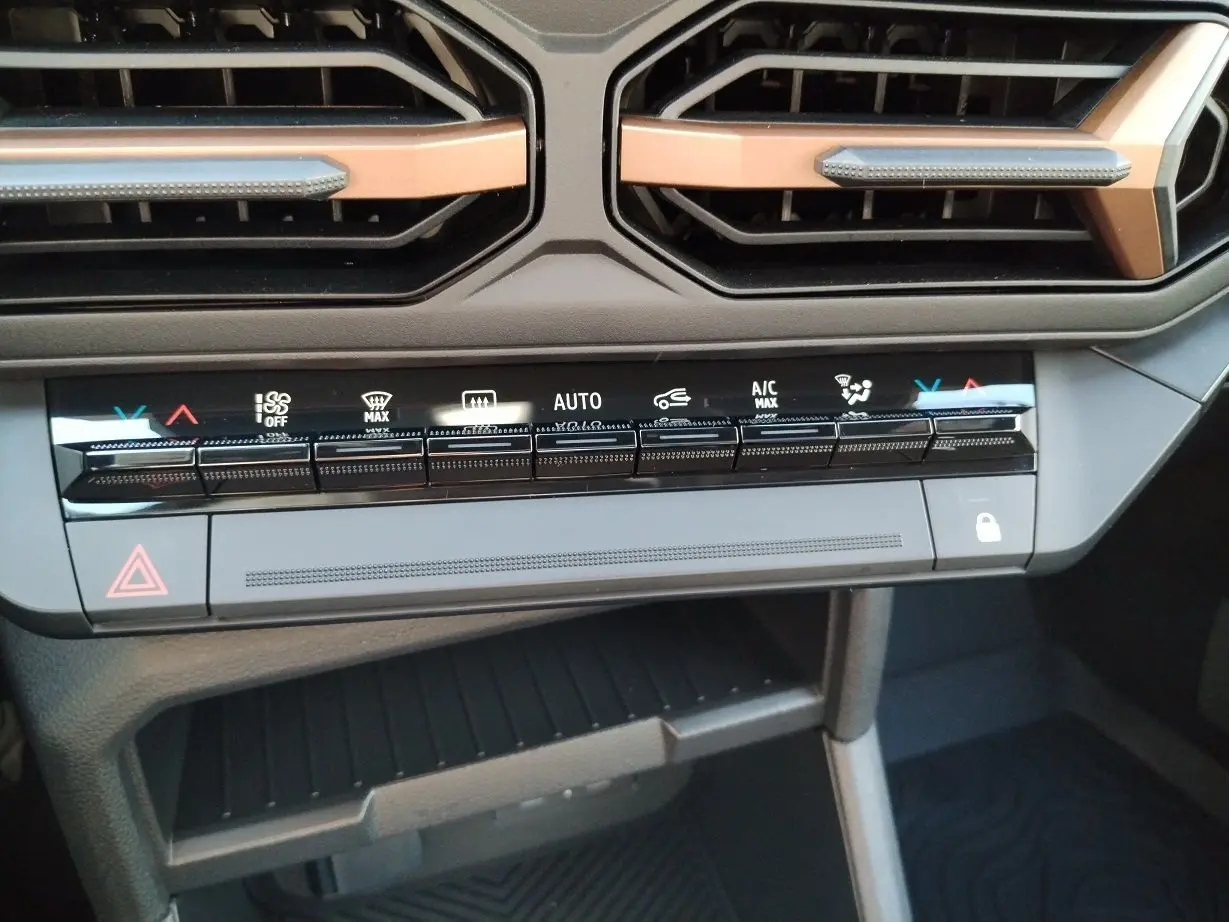 Vue rapprochée du tableau de bord noir du Dacia Bigster 2025, mettant en valeur les commandes tactiles de la climatisation.