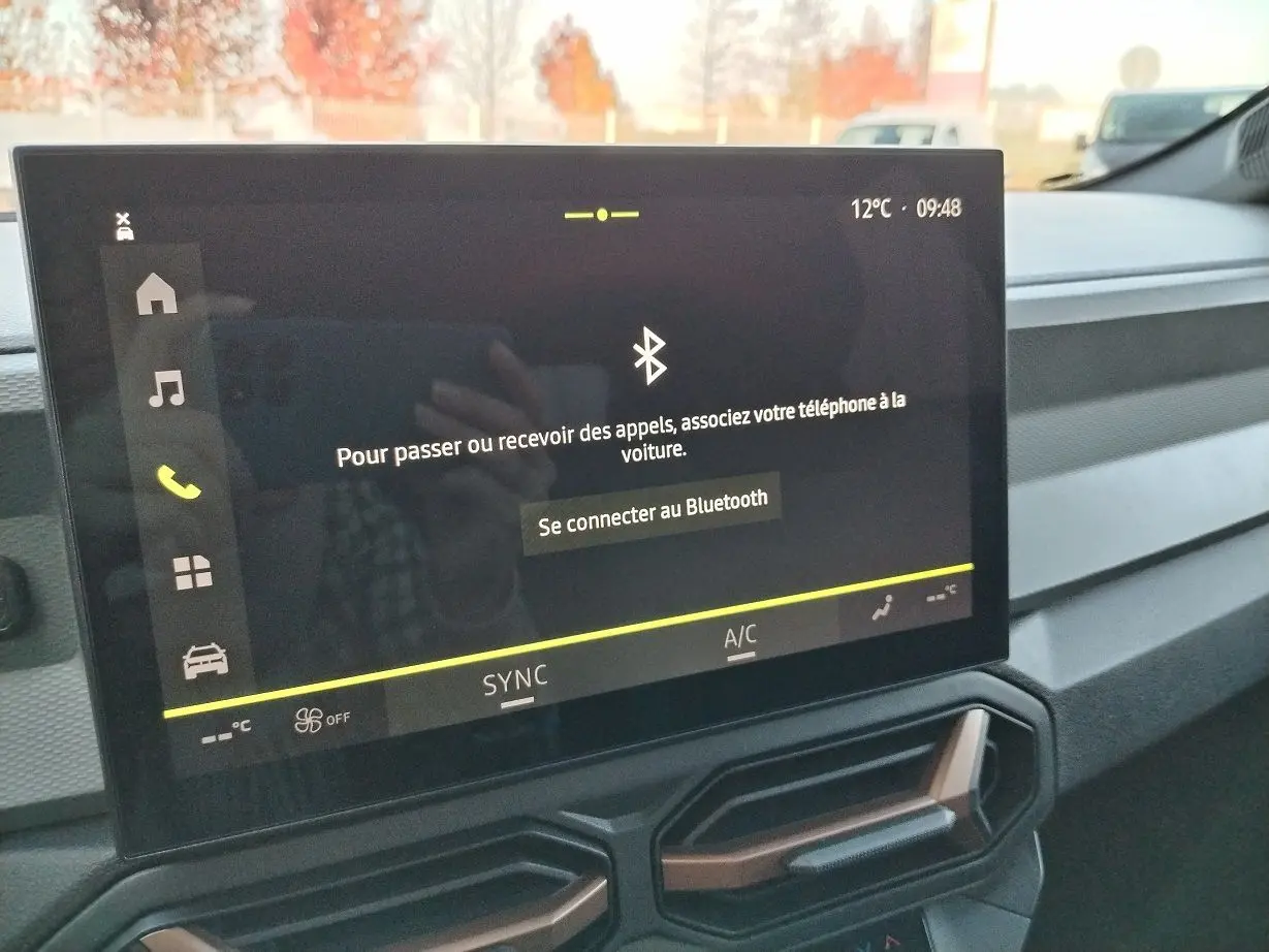 Écran tactile central du tableau de bord du Dacia Bigster 2025 affichant la connexion Bluetooth, avec aérateurs hexagonaux en dessous.