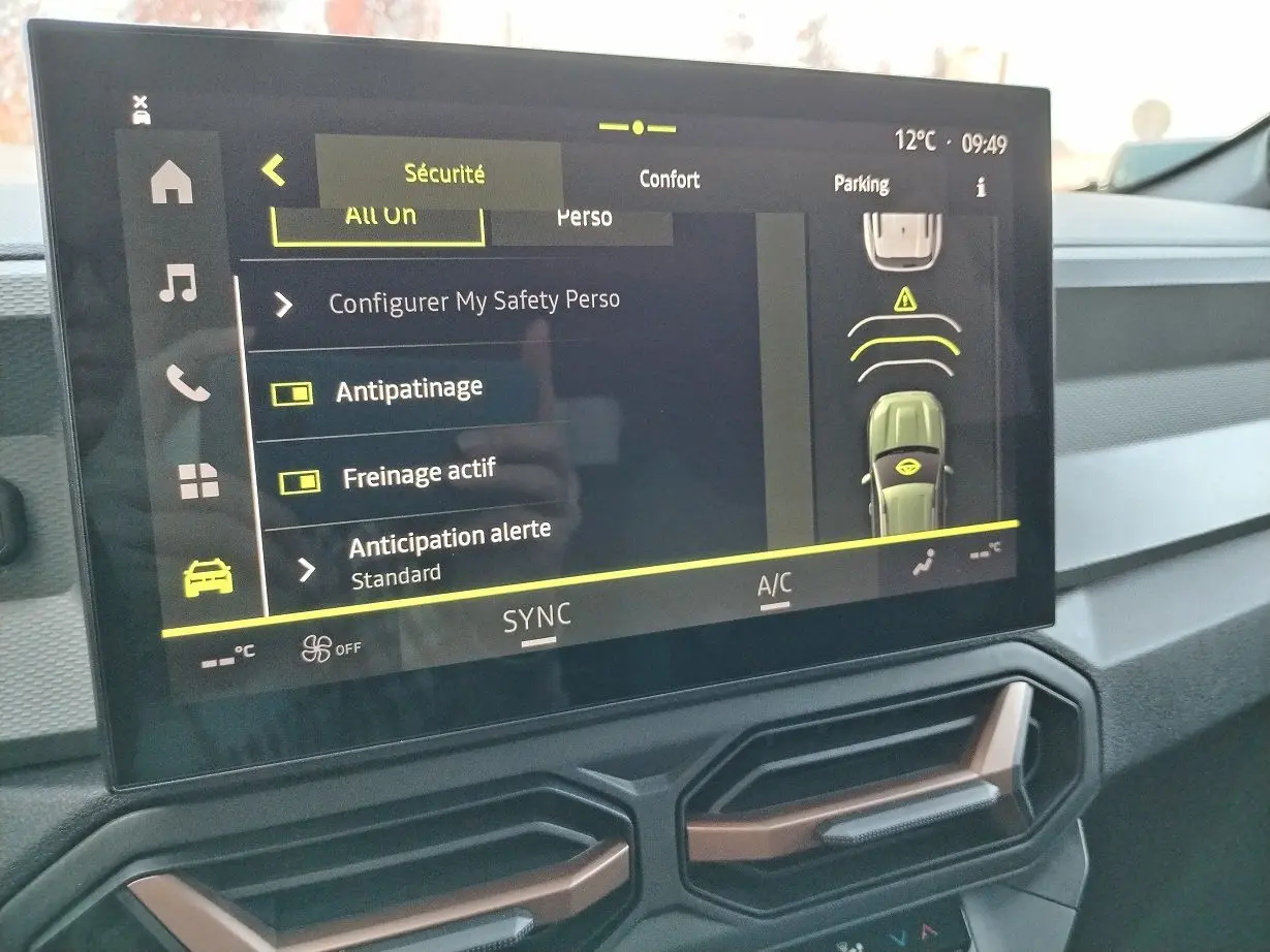 Vue intérieure du tableau de bord du Dacia Bigster 2025 noir, écran tactile affichant les options de sécurité et de confort.