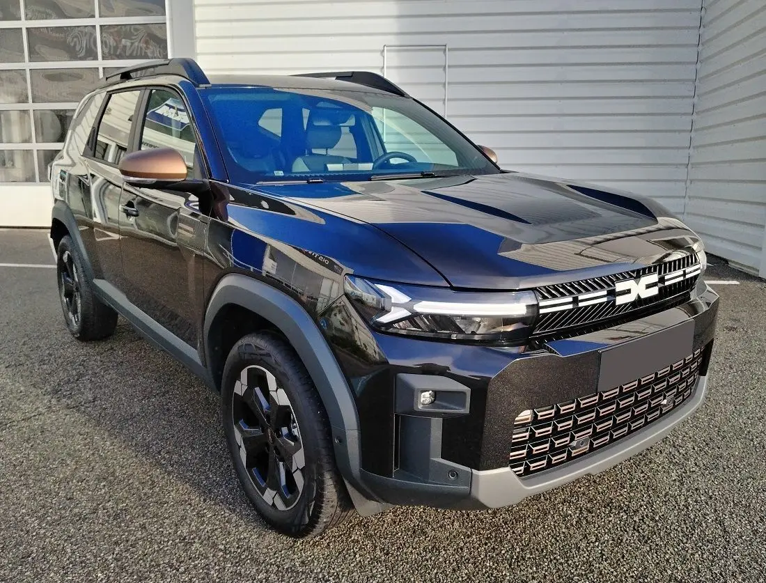 SUV Dacia Bigster noir en 3/4 avant droit avec jantes noires et rétroviseurs bronze métallisé.