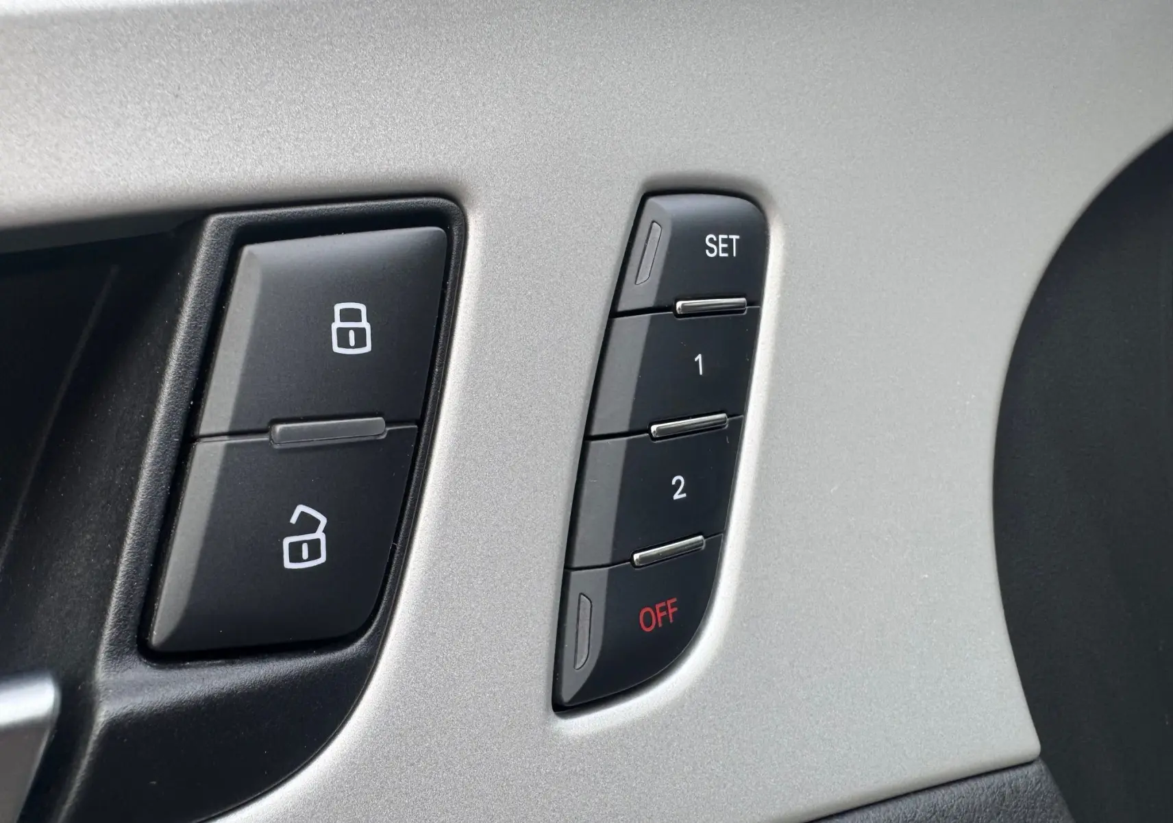 Boutons de réglage mémoire des sièges et verrouillage des portes sur la porte intérieure d'une Audi A6 Avant noire.
