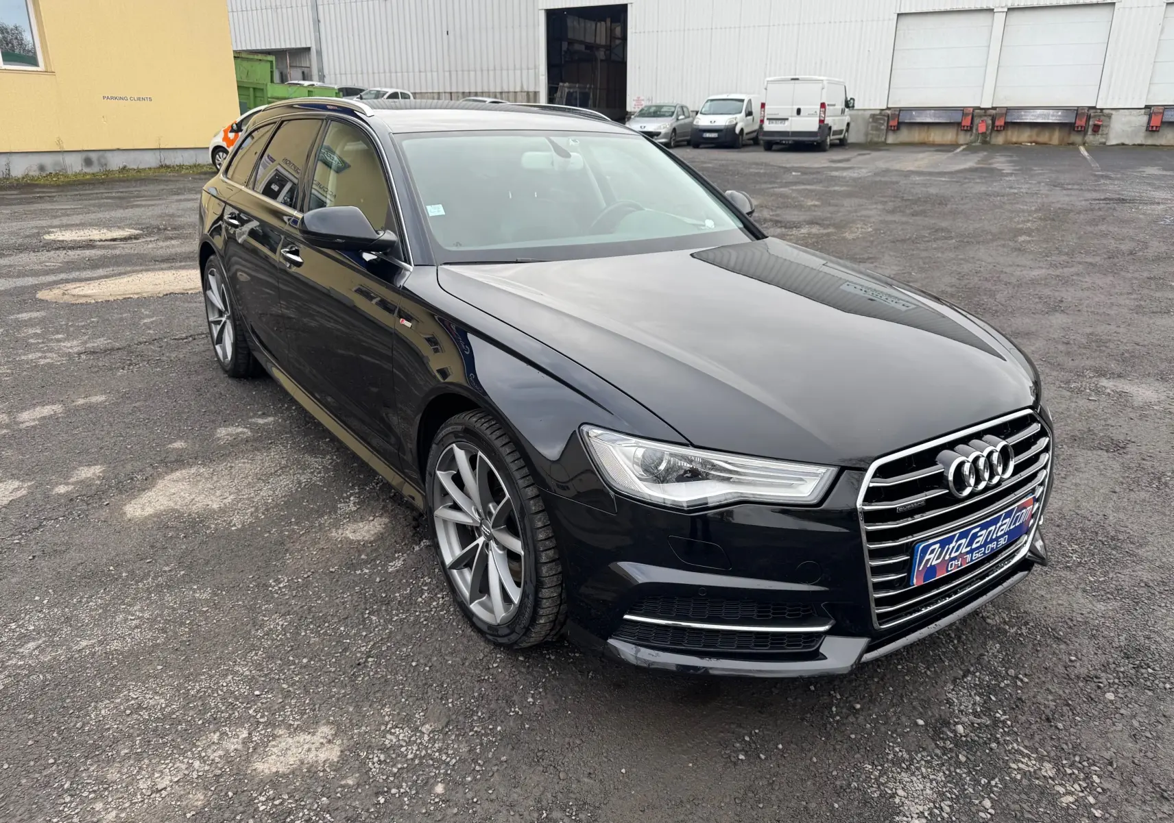 Audi A6 Avant noire vue en 3/4 avant droit, avec jantes alliage et calandre chromée distinctive.