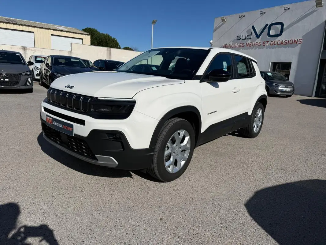 Jeep Avenger blanc en vue 3/4 avant droit, avec calandre noire et jantes alliage 17 pouces visibles.
