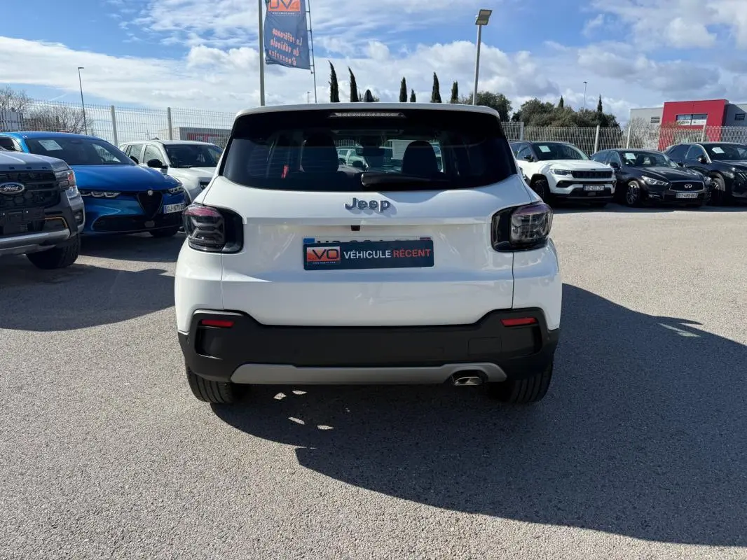 Vue arrière d'un Jeep Avenger blanc 2025 avec feux arrière fumés et pare-chocs noir contrastant.