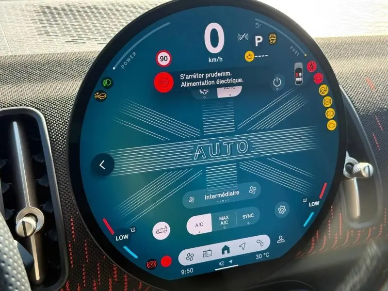 Gros plan sur l'écran circulaire digital du tableau de bord du MINI Countryman argenté, affichant les réglages automatiques.