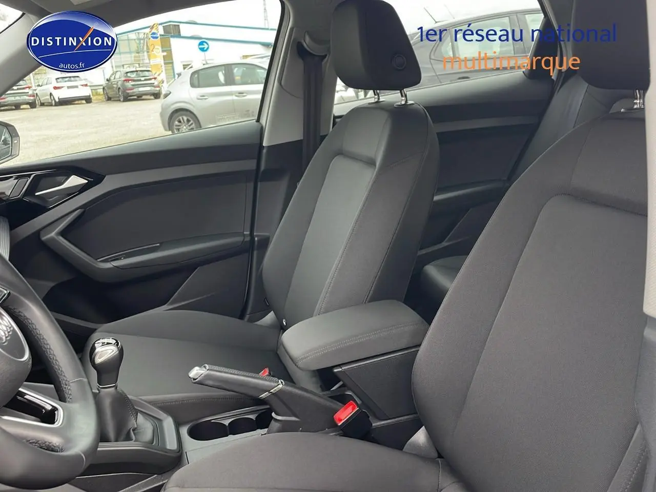 Vue intérieure de l'Audi A1 Sportback 30 TFSI 110 Proline 2022, sièges avant noirs avec accoudoir central.