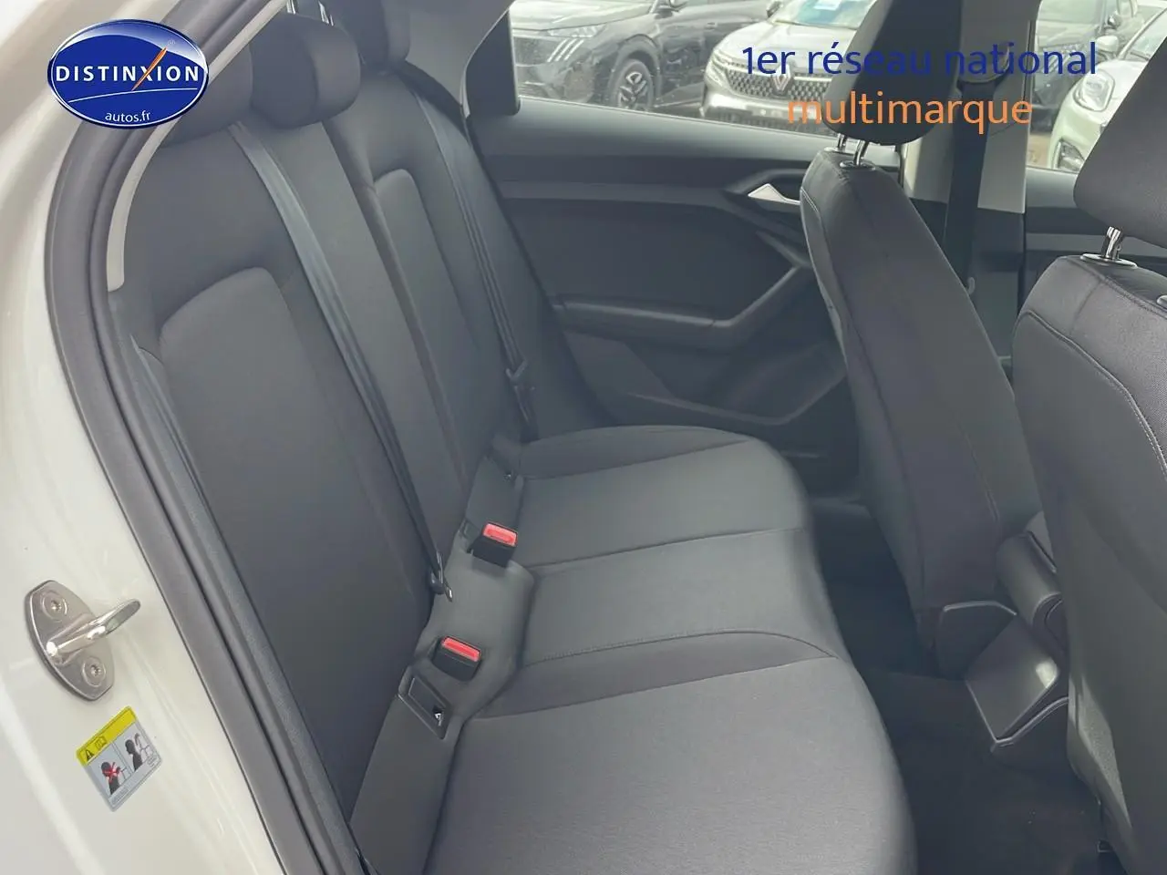 Vue intérieure côté gauche de la banquette arrière noire d'une Audi A1 Sportback blanche 2022.