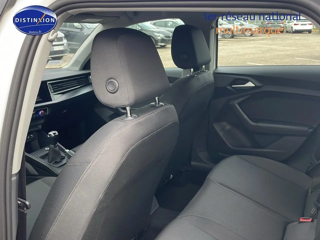 Vue intérieure arrière gauche de l'Audi A1 Sportback 30 TFSI 110 Proline 2022 avec sièges tissu noirs et boîte manuelle.