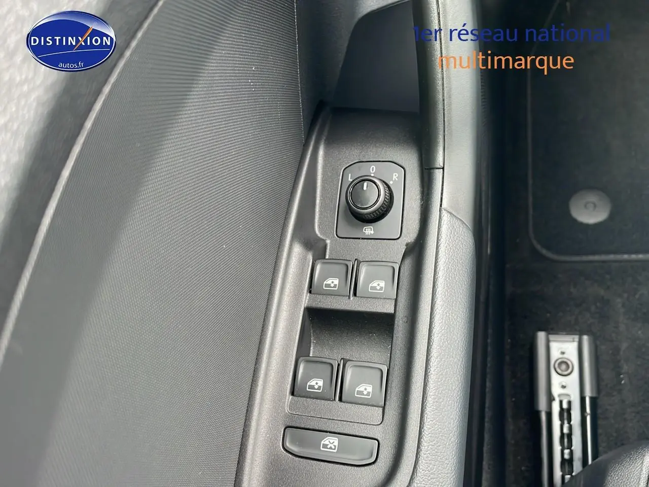 Gros plan sur les commandes de lève-vitres et réglage des rétroviseurs côté conducteur d'une Audi A1 Sportback blanche 2022.