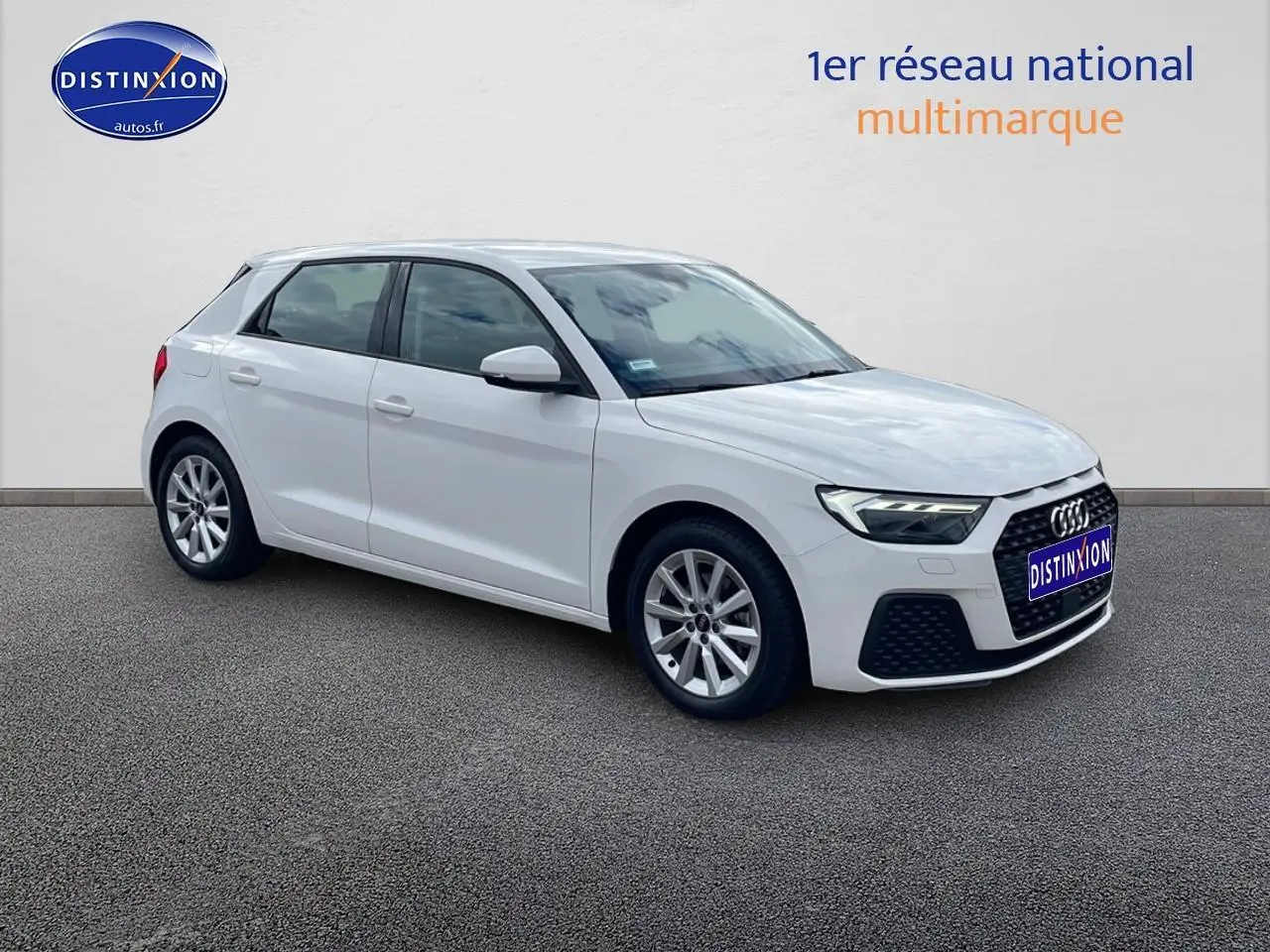 Audi A1 Sportback blanc vue 3/4 avant côté gauche, avec jantes alu 16 pouces et calandre noire distinctive.