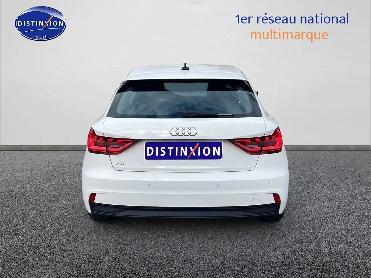 Vue arrière d'une Audi A1 Sportback blanche 2022 avec feux LED et logo distinctif sur fond neutre.