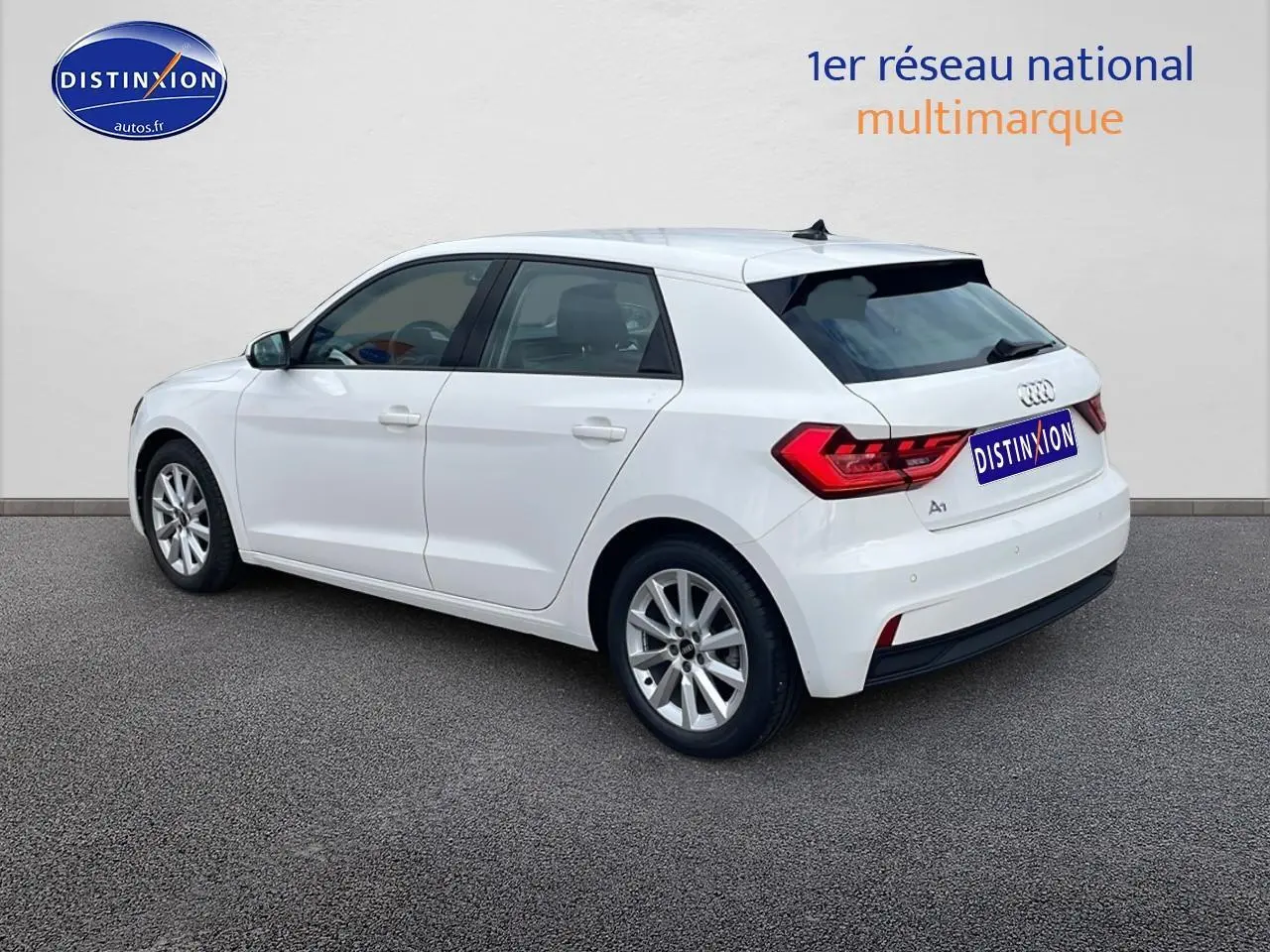 Audi A1 Sportback blanc vue 3/4 arrière côté gauche, avec jantes alu 16 pouces et feux arrière LED distinctifs.