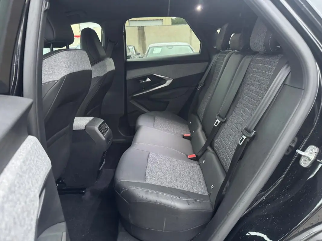 Vue intérieure arrière côté droit du Peugeot 3008 Hybrid 145 Allure 2025, sièges bi-matière gris et noir.