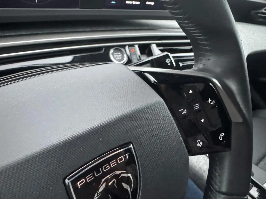 Gros plan sur le volant noir du Peugeot 3008 Hybrid 145 e-DCS6 Allure 2025 avec commandes tactiles intégrées.