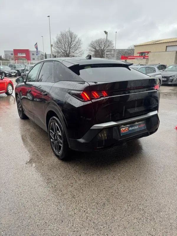 Vue 3/4 arrière droite d’un Peugeot 3008 Hybrid 145 noir avec feux arrière allumés et jantes alliage 19 pouces.
