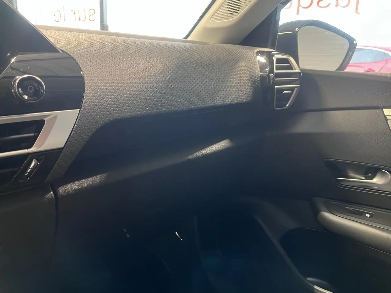 Vue intérieure côté passager de la Citroën C4 2025 noir métal, avec tableau de bord texturé et aérateurs argentés.