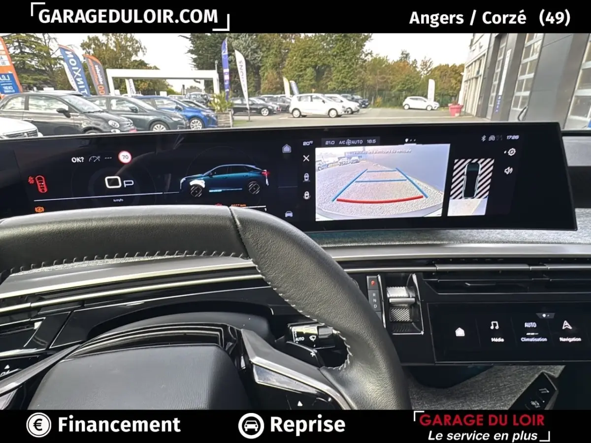Vue intérieure du tableau de bord du Peugeot 3008 1.2 Hybrid 136 Allure 2024, écran multifonction et caméra de recul visibles.