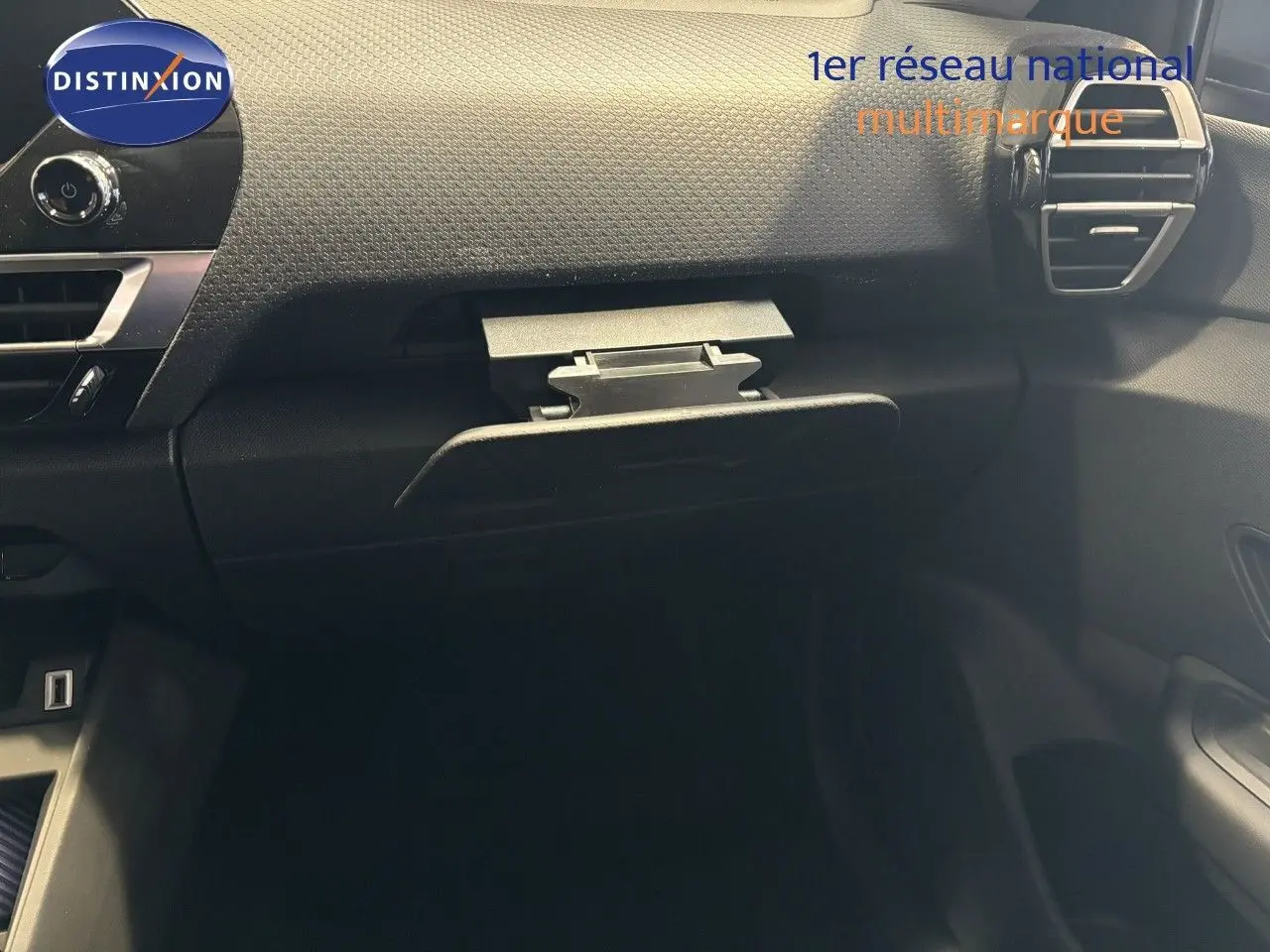 Intérieur de la Citroën C4 2022, vue sur la boîte à gants ouverte côté passager, tableau de bord noir texturé.
