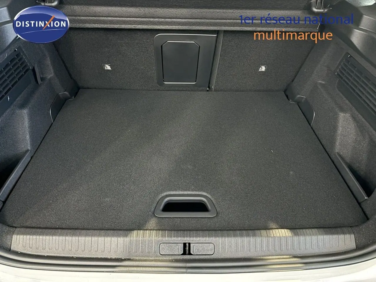 Coffre ouvert d'une Citroën C4 blanche de 2022, vue de l'arrière montrant un espace de chargement propre et spacieux.