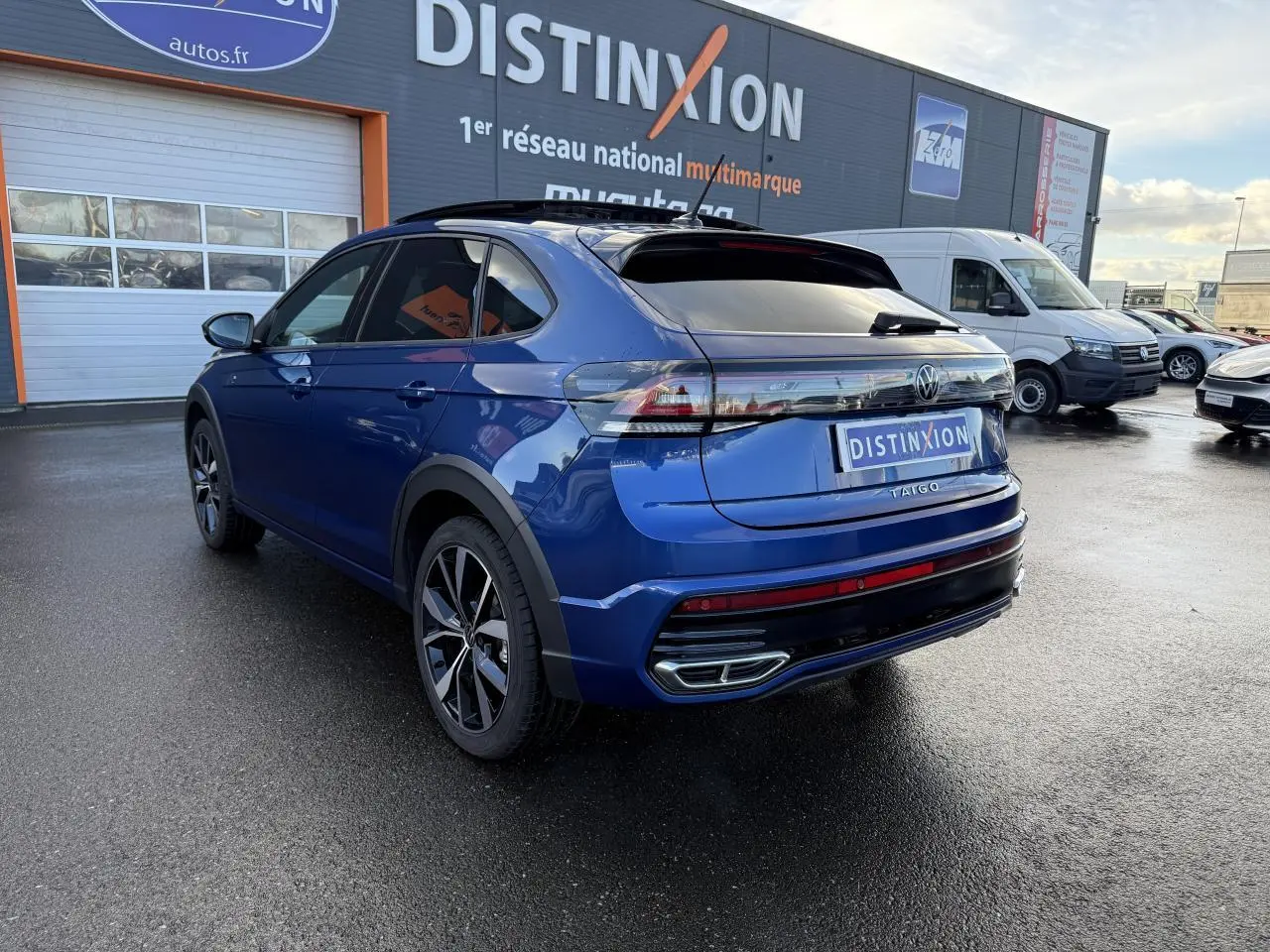 Volkswagen Taigo bleu récif métallisé vu 3/4 arrière droit avec jantes noires brillantes et toit ouvrant en verre