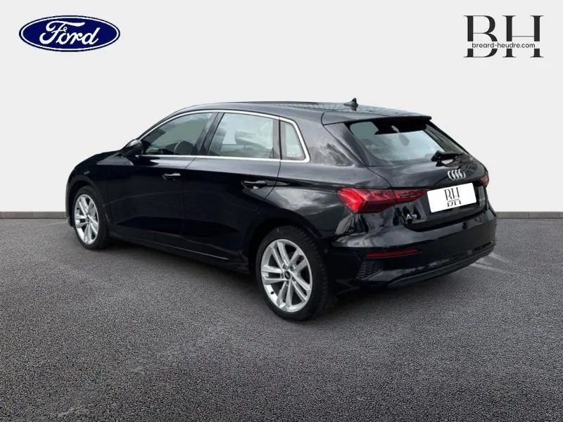 Audi A3 Sportback noir Mythic métallisé vue 3/4 arrière droit, jantes alu et feux arrière LED distinctifs.