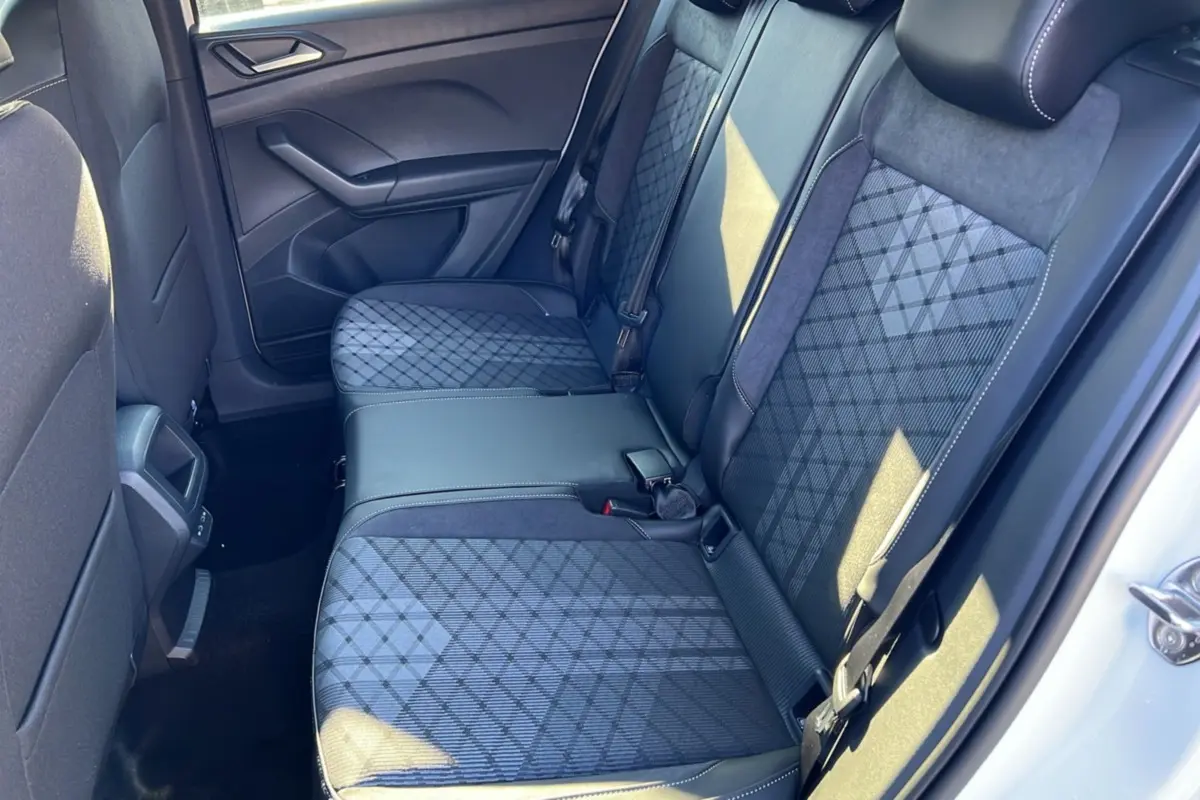 Vue intérieure côté droit sur la banquette arrière tissu gris à motifs géométriques du Volkswagen T-Cross blanc pur 2025.