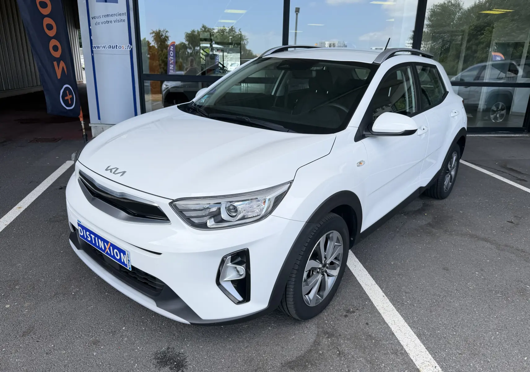 KIA Stonic blanc en 3/4 avant droit, SUV compact avec calandre noire et jantes alliage bicolores.