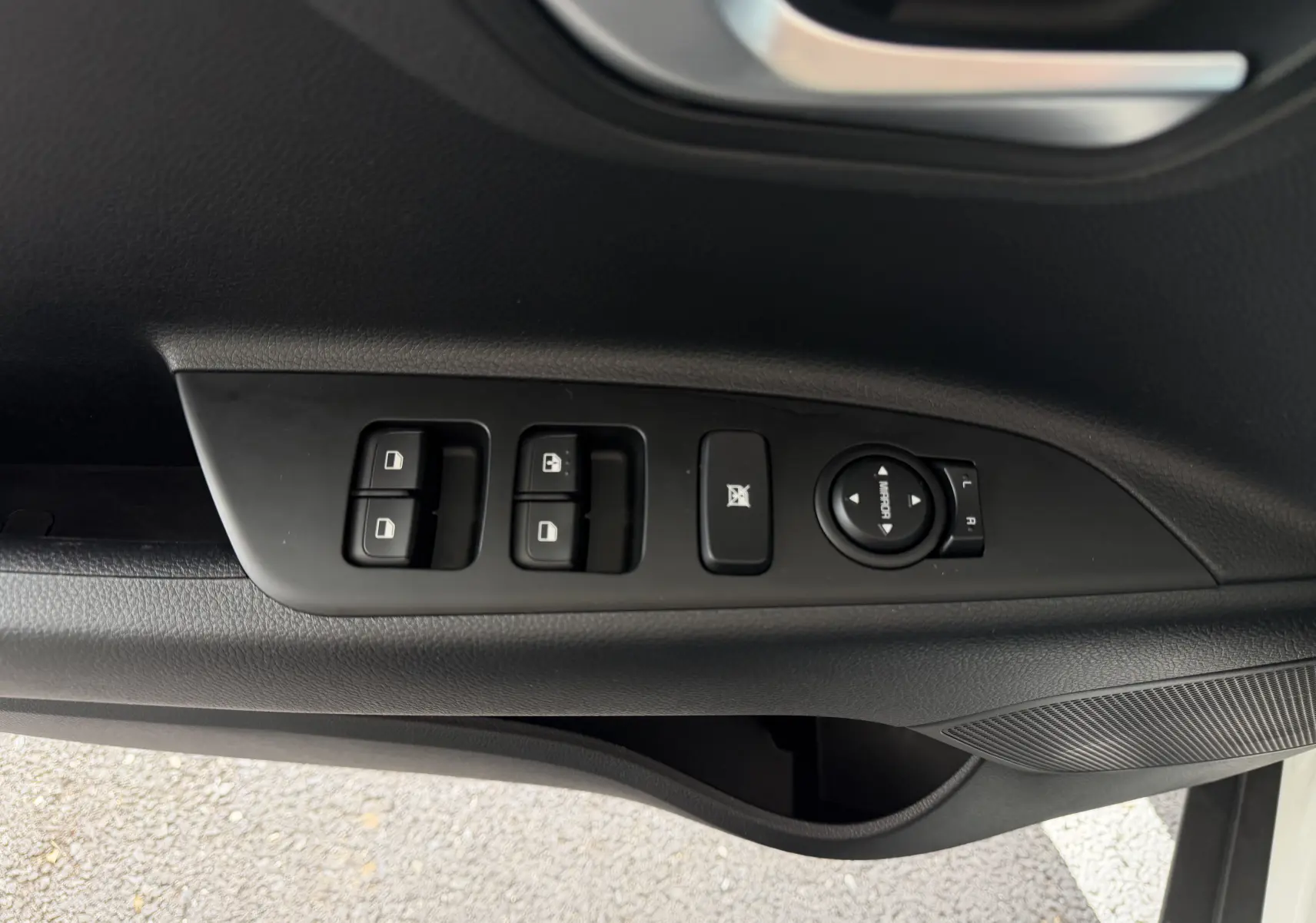 Vue rapprochée côté gauche des commandes de lève-vitres et réglage des rétroviseurs sur porte noire d’un KIA STONIC blanc.