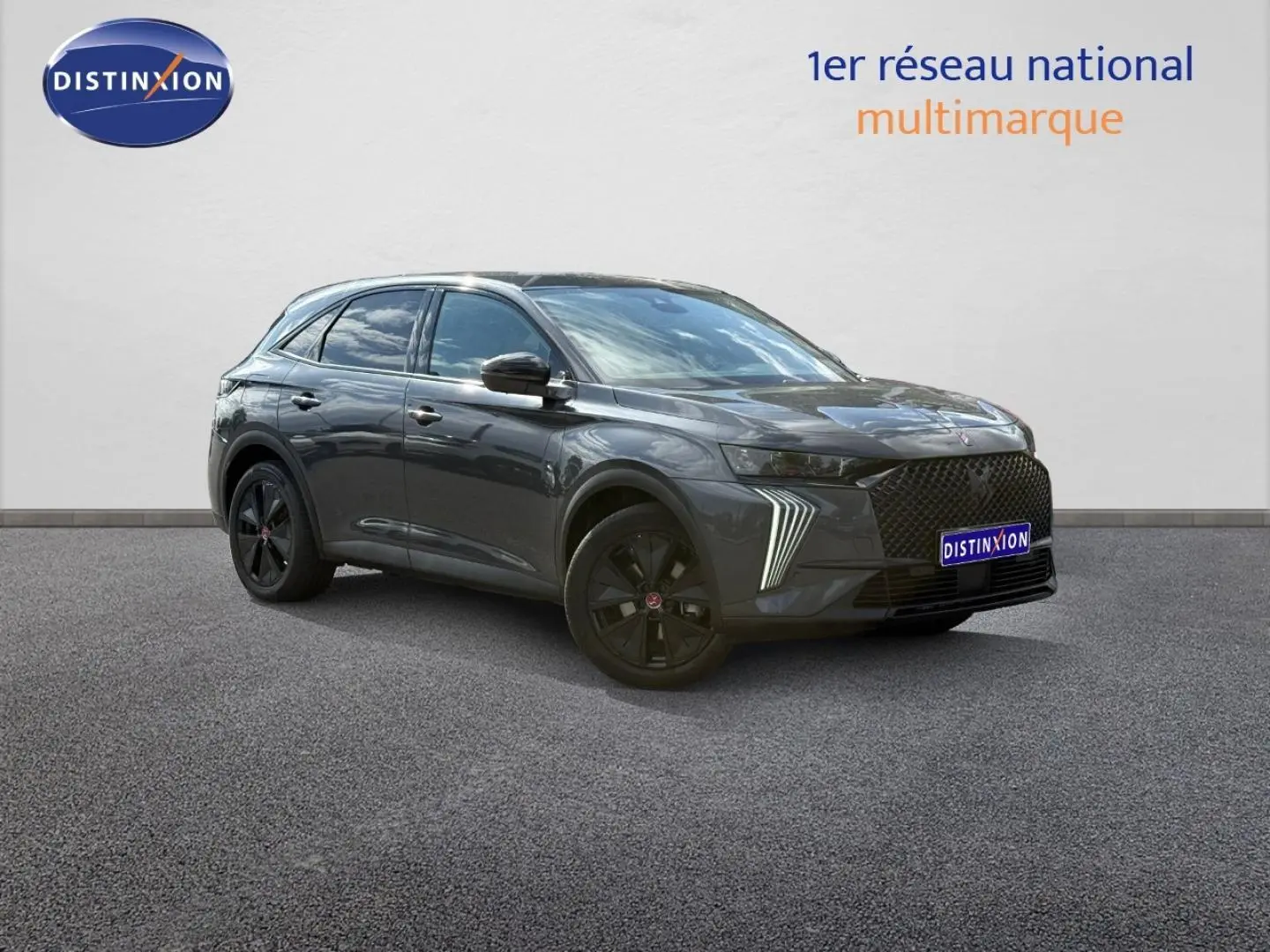 DS7 E-TENSE gris titane vu en 3/4 avant droit, avec jantes noires et feux LED distinctifs allumés.