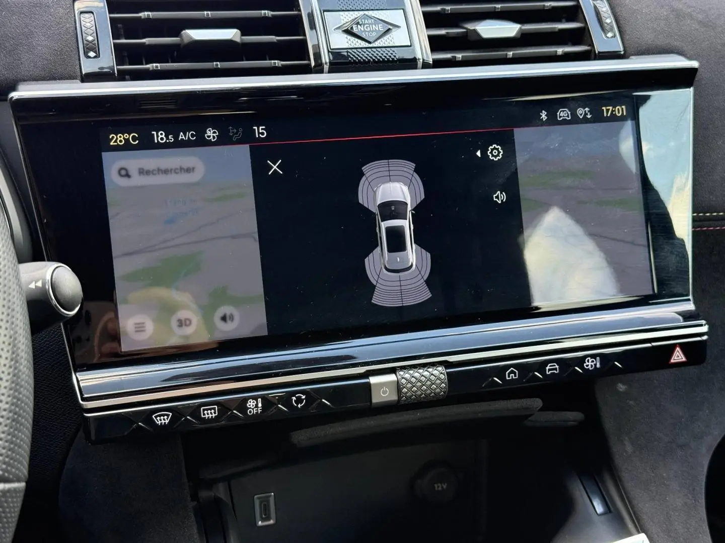 Vue rapprochée de l'écran tactile central du DS7 E-TENSE 2024 affichant l'aide au stationnement et la navigation.