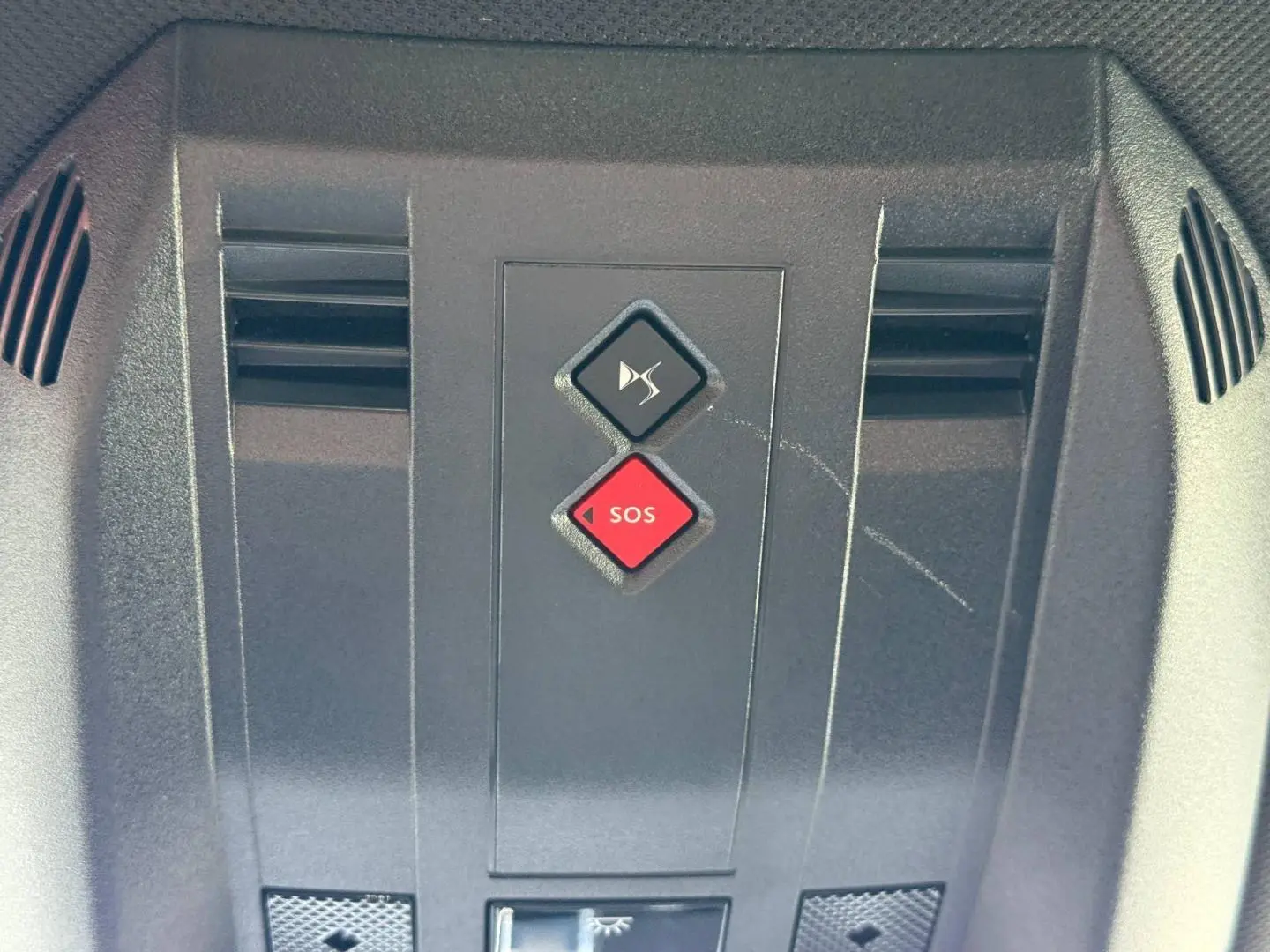 Gros plan sur la console de toit noire avec boutons SOS rouge et désactivation son DS7 E-TENSE 2024.